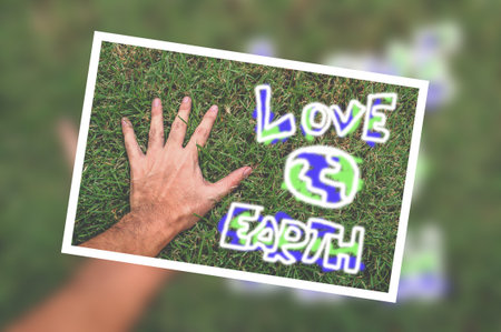 photo hand and word love earth on green grassの写真素材