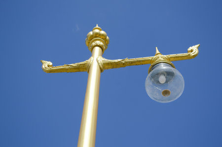 gold lamp pole on blue skyの写真素材