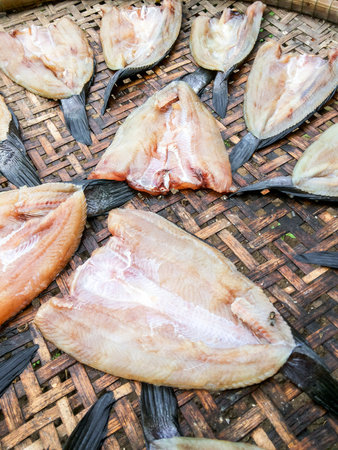 Dry salted fish on bamboo floorの写真素材