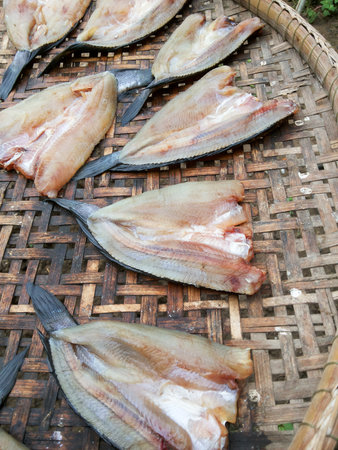 Dry salted fish on bamboo floorの写真素材