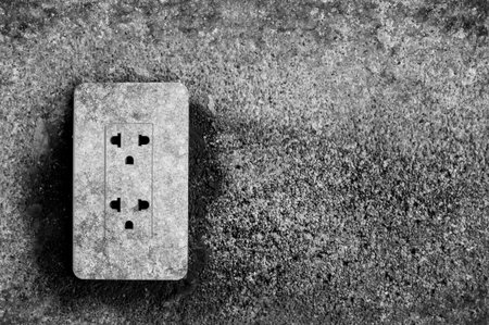 black and white of plug on grunge wall backgroundの写真素材