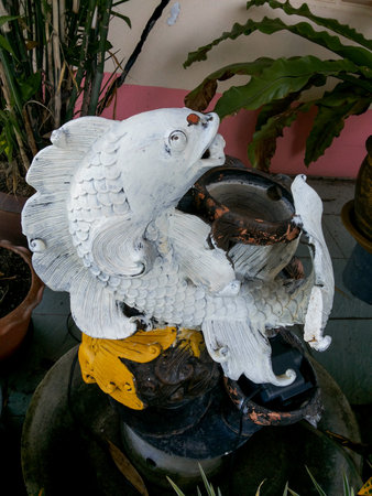 old fish statue in gardenの写真素材