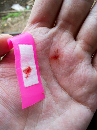 pink bandage on man hand