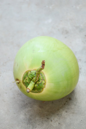 green coconut fruit on cement floorの写真素材