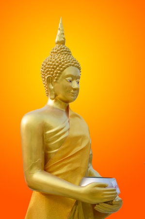 gold buddha statue on orange color backgroundの写真素材