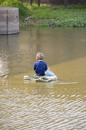 Man asia local fisher working by cast a net in canal country Thailandのeditorial素材