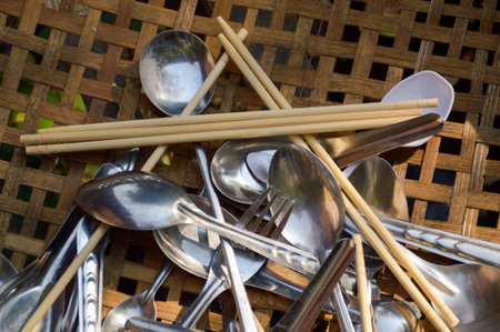 spoon and chopsticks on bamboo basketの写真素材