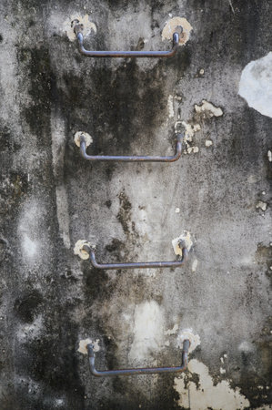 close up old iron stair on dirty cement wall