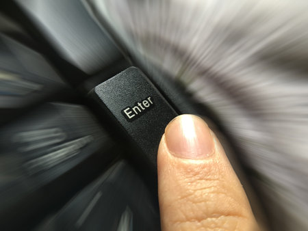 close up human finger press enter button on computer keyboardの写真素材