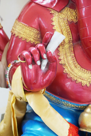 Close up red hand Ganesha statue in public temple at Thailandの写真素材