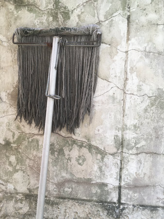 old mop on cement wall