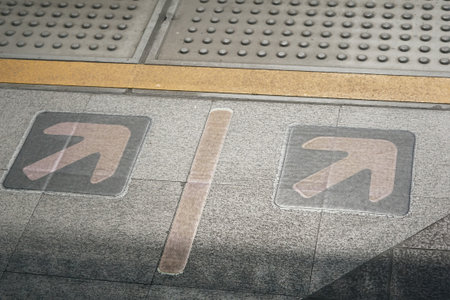 close up arrow sign on floor in subway