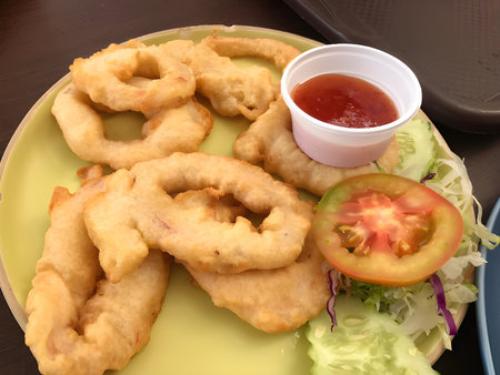 fried fish rings with sauce and tomatoの写真素材