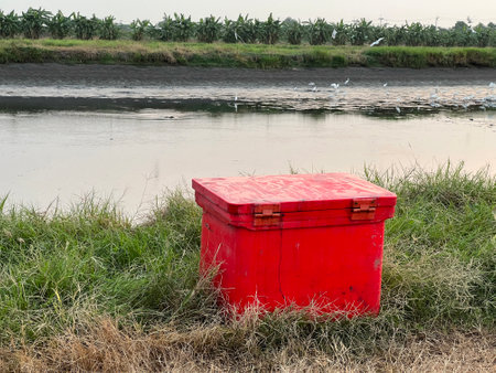 red plastic trash can on the ground in the countrysideの写真素材