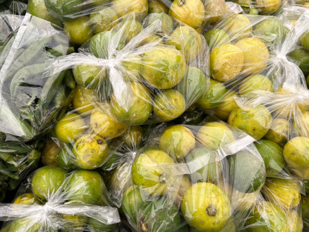 green and yellow orange fruit in plastic bagの写真素材