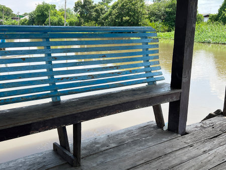 old wooden bench and a boat on the river in thailandの写真素材