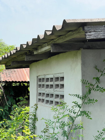 old brick wall with a roof and a tree