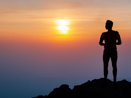 silhouette of man with backpack and mountain on sunset background. travel and adventureの素材