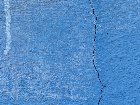 texture of a concrete wall with cracks and scratches which can be used as a backgroundの写真素材