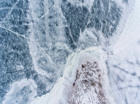 Aerial top down view over icy lake surface pattern, near Latazeris village. Winter season in...