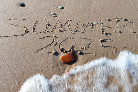Summer 2025 text written on beach sand background. Good bye 2024 hello to 2025 happy New Year coming concept. top view.の写真素材