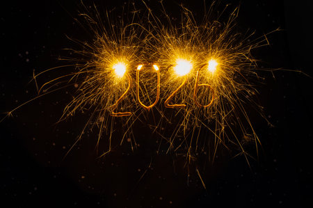 Festive New Year concept featuring the number 2026 written with bright sparkler fireworks on a dark...