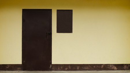 Yellow wall with brown door, minimalismの写真素材