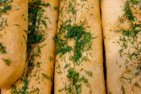 fresh baked bread in a bakery French baguette sprinkled with fresh herbs dill
