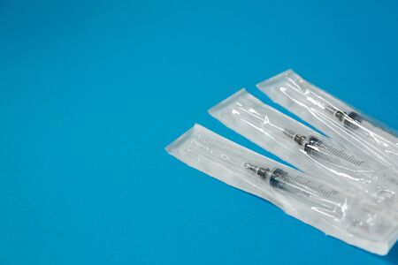 medicine, syringe in a blister on a blue background side viewの写真素材