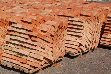 Red brick pallet at a construction site, closeup. Construction material