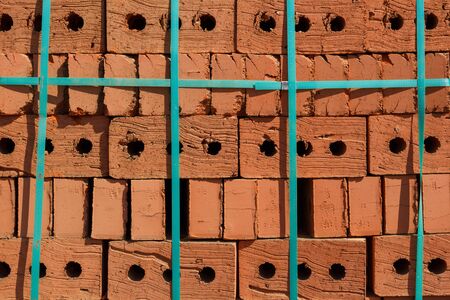 Background and texture. Red brick pallet at a construction site, closeup