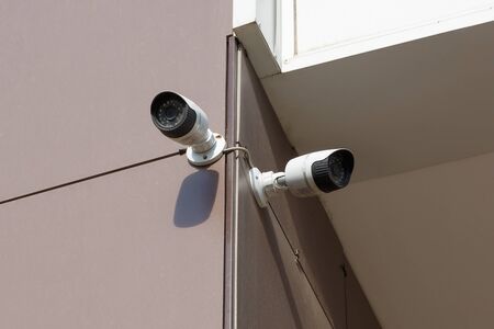 Security camera on the wall of an office building. Modern security technologies to protect private property. Videcam.の写真素材