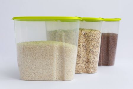 various groats in containers or jars on a white background. Rice, oatmeal and buckwheatの写真素材