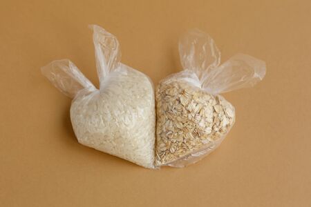 various groats in small plastic bags on a brown background. Rice and oatmealの写真素材