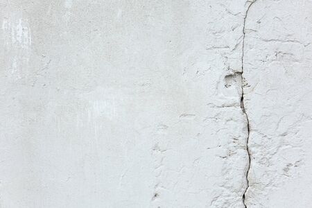 Texture and background. White old concrete wall with a crack. Repair and constructionの写真素材
