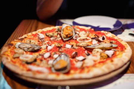The food in the restaurant. Pizza with seafood and mussels, squid and octopusの写真素材