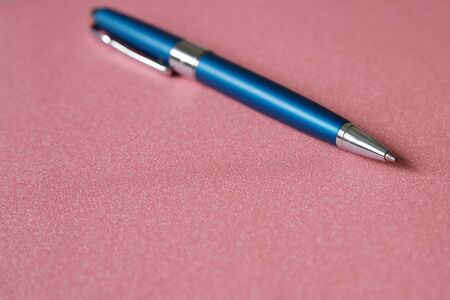 Metallic blue ballpoint pen on a pink background. Background and texture for designerの写真素材