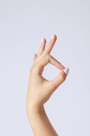 Gesture and sign, female hand on a white background. Fingers showing ok or goodの写真素材