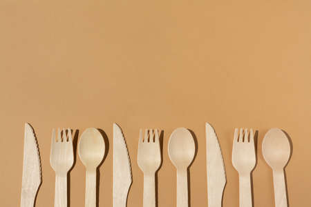 Contrast lighting. Flat lay. Eco friendly wooden cutlery. Fork and knife, spoon. Plastic Free Concept.の写真素材