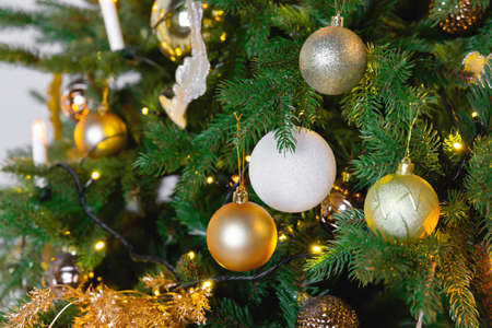Christmas toy ball hanging on a branch of spruce. New year tree decorated with a garland.