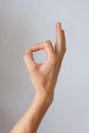 Gesture and sign, male hand on a white background. Fingers showing ok or goodの写真素材