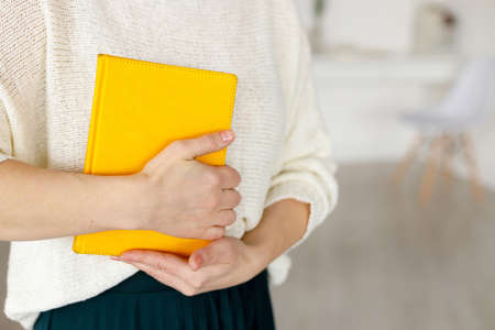 woman businessman holding a yellow notepad. Business planning and tasks for the day or week. Female in businessの写真素材