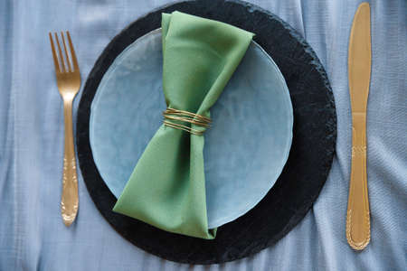 festive table setting, napkin on plate. Dishes in interior