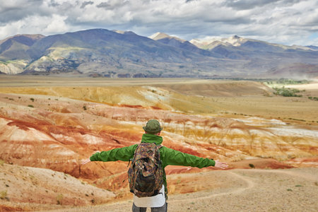 man tourist spread his arms in an embrace, against backdrop of landscape. Sights of Russia, Siberia and Altai Republic, mars field. Tourism, travel and adventure. Kosh-agach, Chagan-Uzunの写真素材