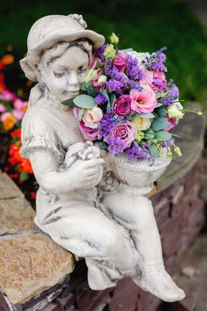 wedding bouquet with rose flowers and eucalyptus lies on a statue of a girlの写真素材