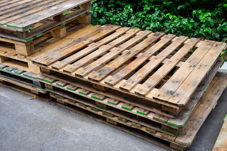old used pallets stacking together in factoryの写真素材