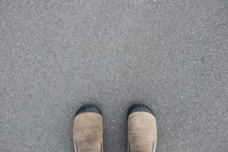brown suede shoes standing on the asphalt concrete floorの写真素材