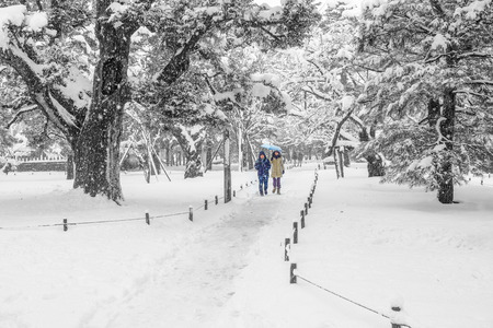 Kanazawa, Japan - January 3, 2015 : A couples walking under snowing in Kenrokuen gardenのeditorial素材