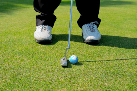 Golfer putting the earth under sunshineの写真素材