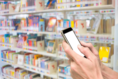 One using smartphone in library surrounding with lot of books in background